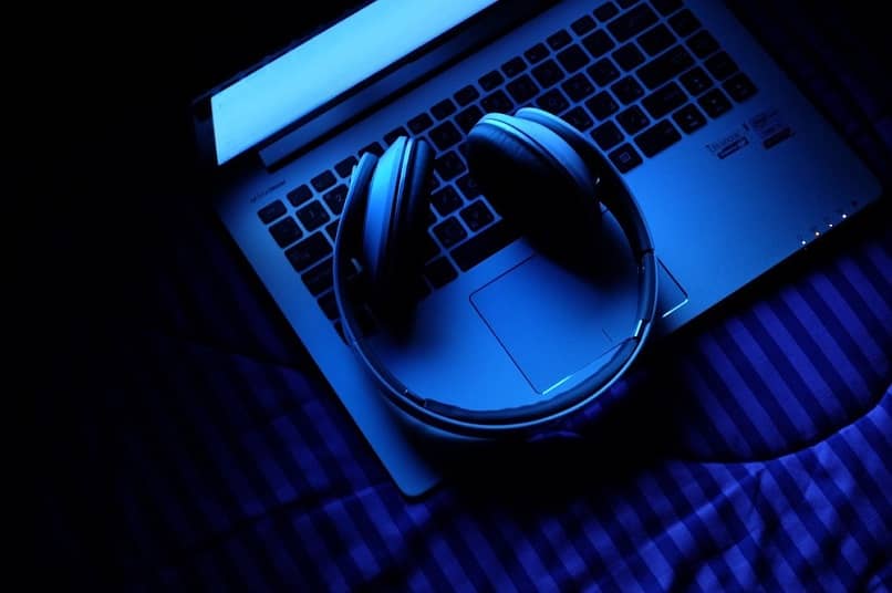 Audífonos sobre portátil con tonalidad en azul