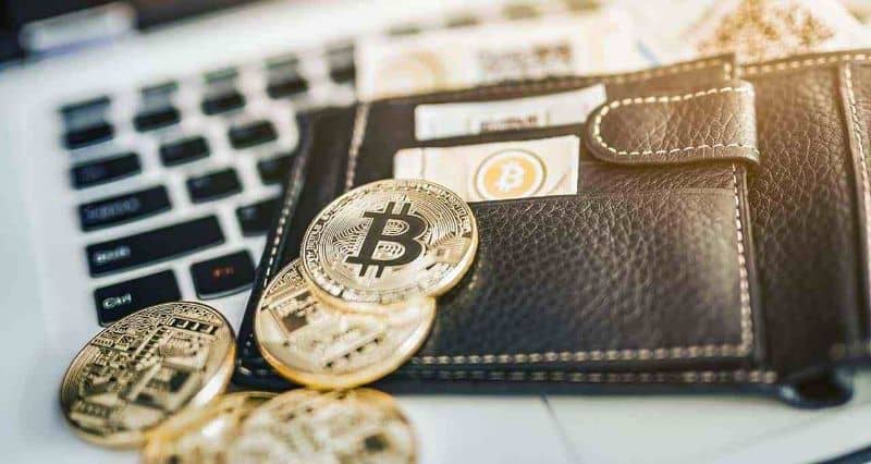 Bitcoin en billetera en la parte superior de la computadora portátil