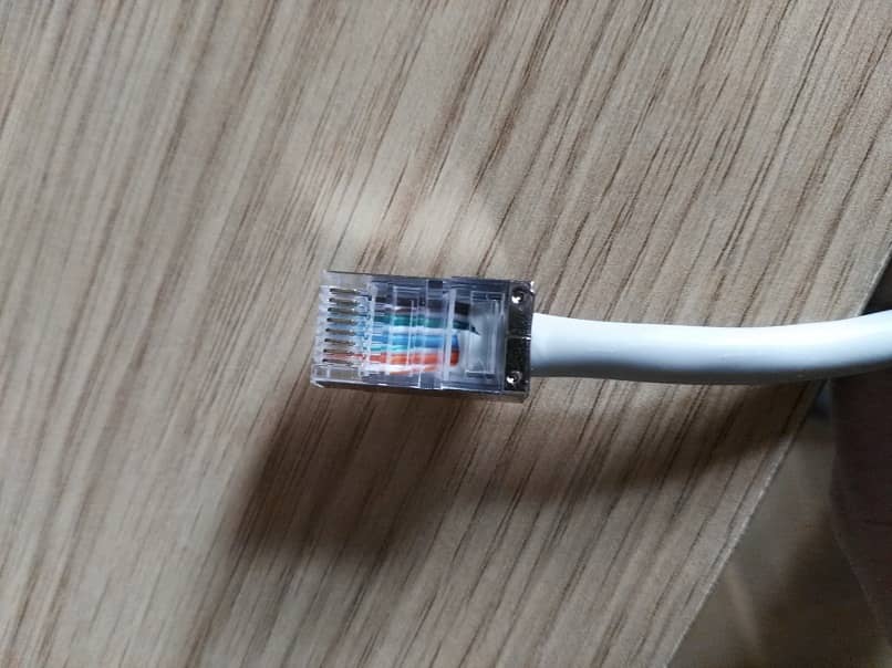 foto anpliada de un cable ethernet blanco con los ocho colores de los cableados internos 