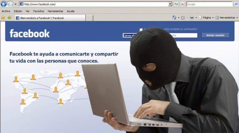 hombre o hacker encapuchado en laptop e inicio de facebook de fondo