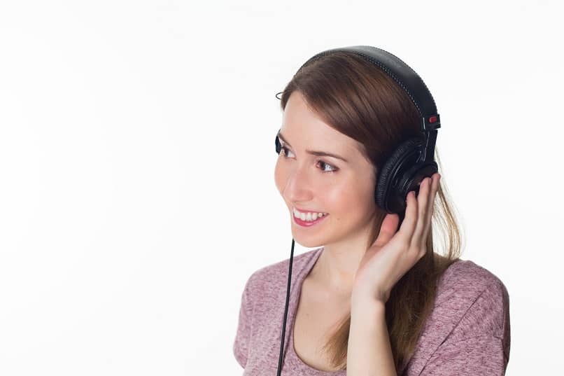 mujer usando audífonos y escuchando